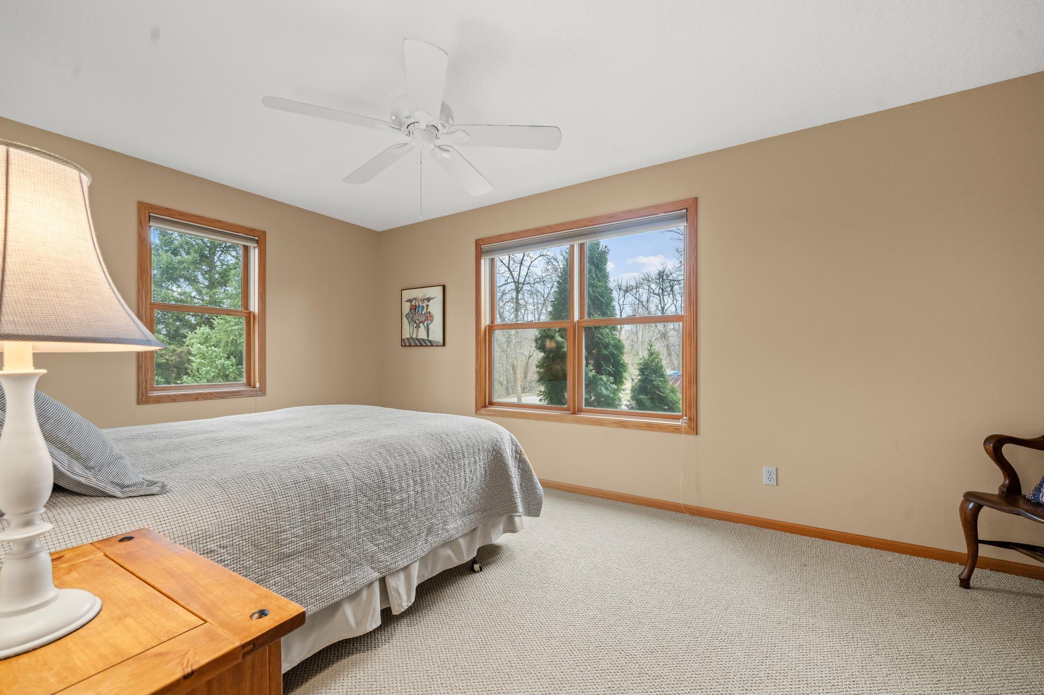 Bedroom in the upper level with views of the woods and pond