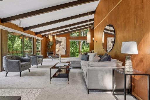 Living room with newer carpet, roller shades. Original wood panel and lighting in this fabulous mid-century modern design. Volumes of space.