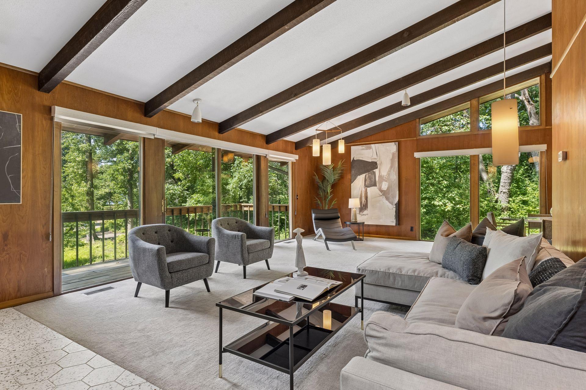 Living room with newer carpet, roller shades. Original wood panel and lighting in this fabulous mid-century modern design. Volumes of space.