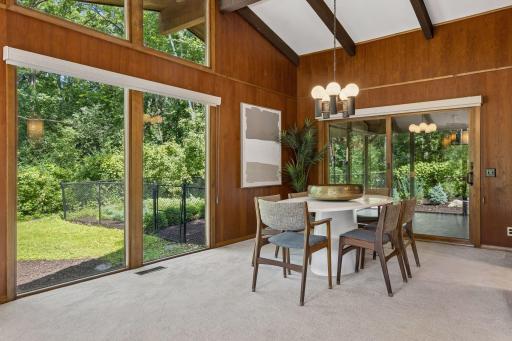 Dining room with newer roller blinds opens to living room. Walk out to screen porch.