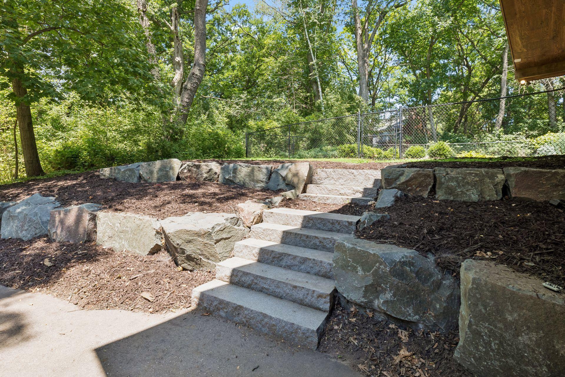 Stone steps lead from driveway area to backyard.
