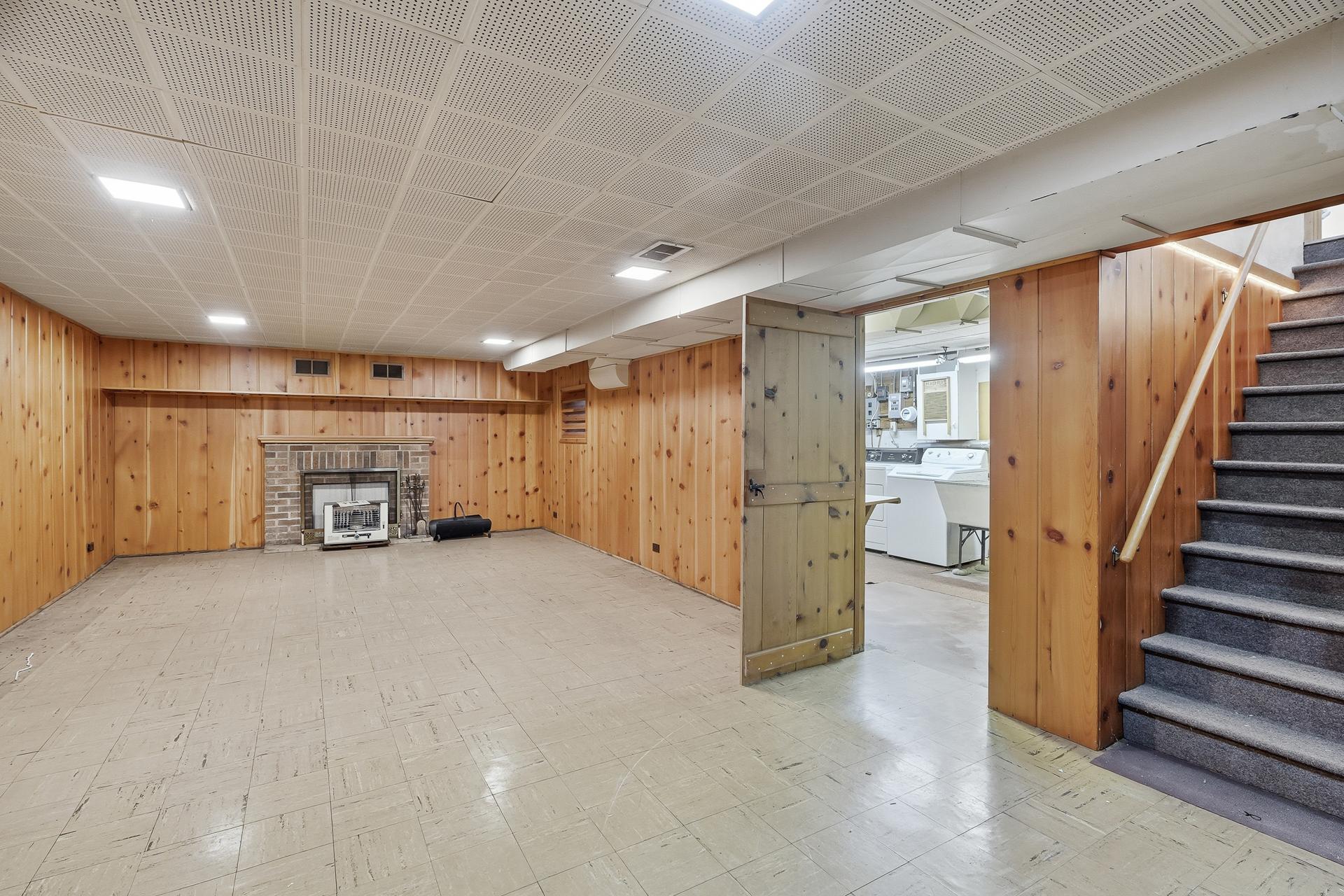 Lower level 13.5x11 Family Room with knotty pine paneling. Wood-burning fireplace has not been used in years, and not deemed to be in working order.
