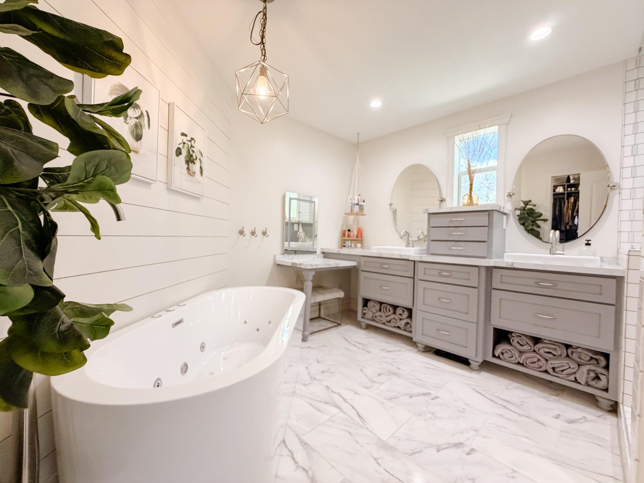 Primary suite full bath with jetted and air freestanding tub, vanity area with built in jewelry and tool drawers