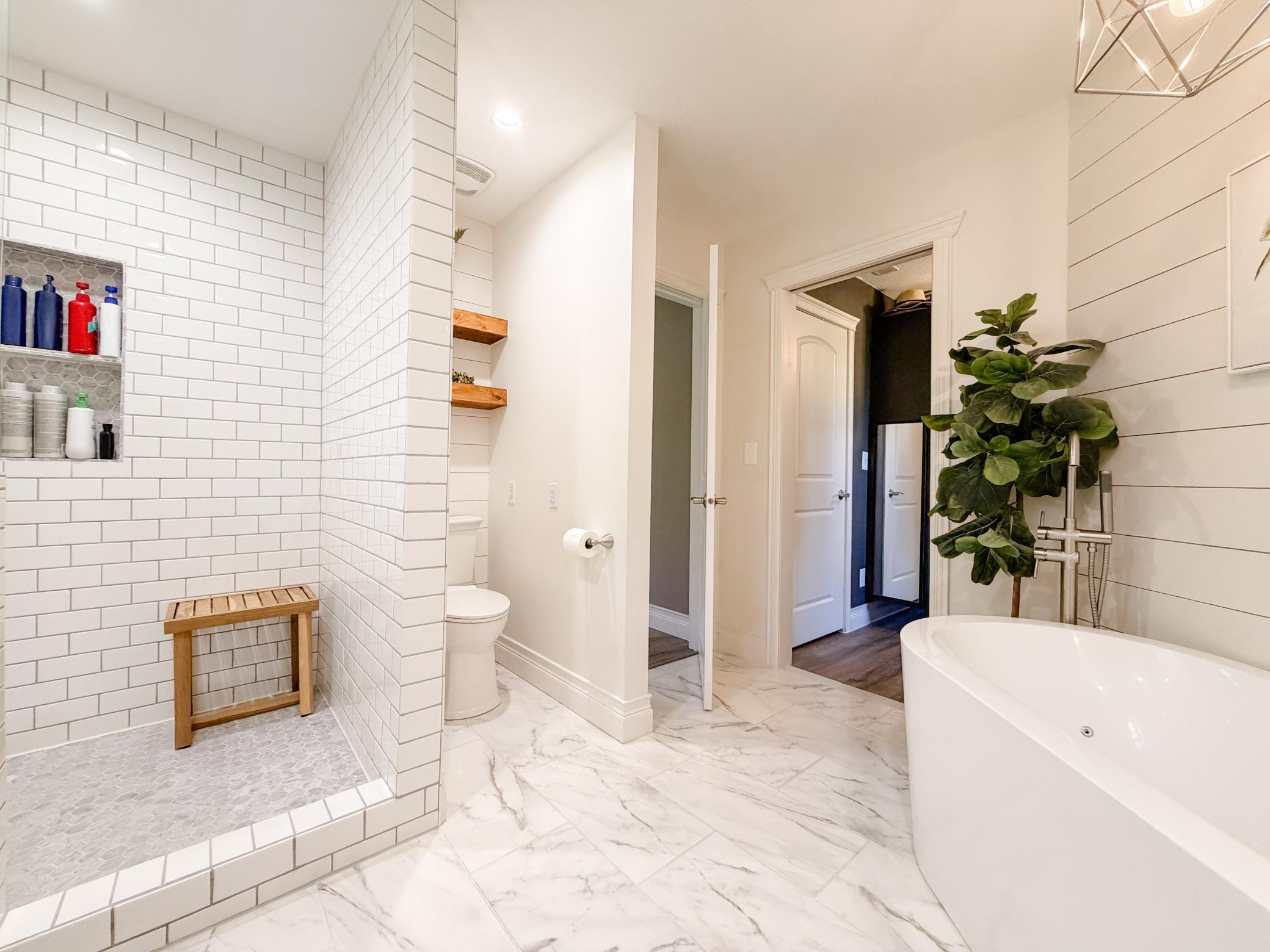 Primary suite full bath with jetted and air freestanding tub and walk in shower.