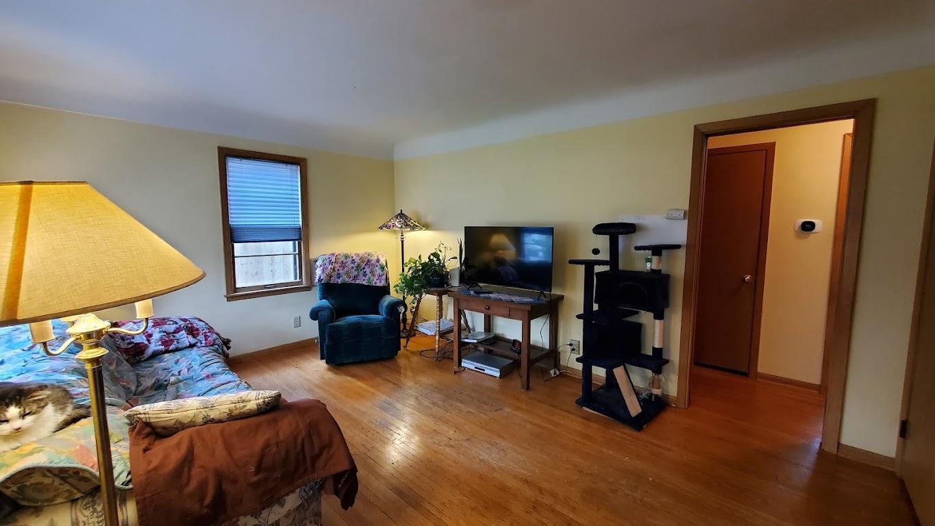 Living room has hardwood floors and coved ceiling.