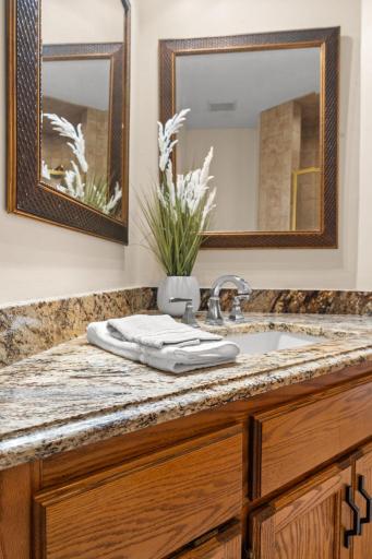 Close-up view of the premium granite countertop, undermount sink, and beautifully preserved oak cabinetry.