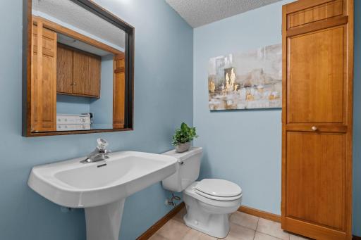 55-web-or-Convenient main floor half bath featuring a clean pedestal sink and built-in linen storage.-14305 44th Ave N-371.jpg