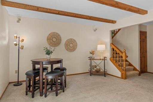 Alternate view of the lower-level rec room showcasing the rustic ceiling beams and convenient layout.