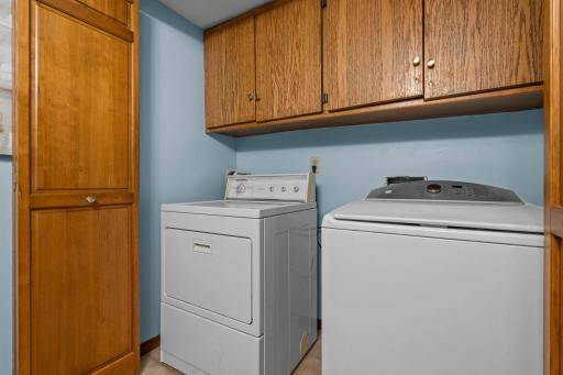 Another view of the functional laundry utility space showcasing the solid wood storage closets.