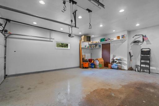 Clean and exceptionally organized garage area with ceiling bike hooks and durable, easy-to-maintain floors.