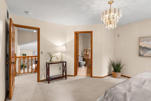 Spacious owner's suite landing area framing views of the open layout below and the upper-level bathroom.