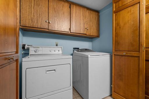 Dedicated laundry room complete with side-by-side washer and dryer plus abundant upper cabinet storage.