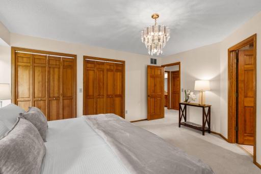 Alternate primary bedroom view showing the deep closet space and a glimpse into the private en suite bath.
