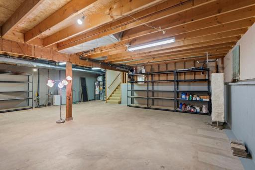 Clean, wide-open basement area highlighting the solid structural beams and easy stairway access.