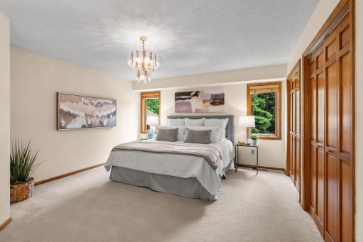 Generously sized primary bedroom retreat featuring a glamorous crystal chandelier and expansive double closets.