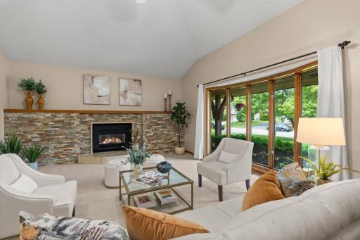 Sun-drenched living area featuring an oversized picture window with peaceful views of the mature trees.