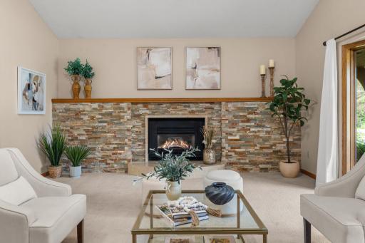 Dramatic floor-to-ceiling stone fireplace serves as a stunning architectural centerpiece for the main floor.