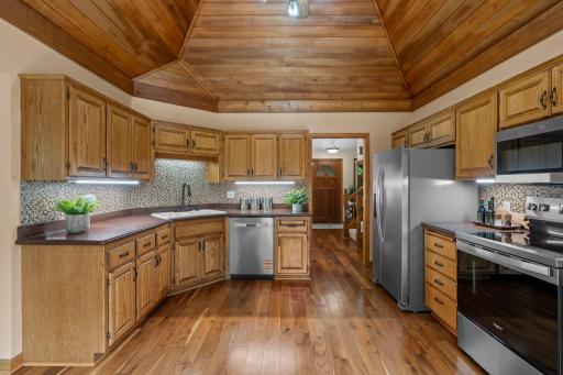 Bright, inviting kitchen space framed by warm oak cabinetry and rich wood floors.