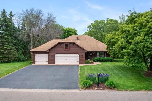 Clear daytime shot of the classic cedar-sided exterior, meticulously maintained lawn, and professional landscaping.