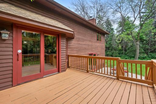 Alternate deck profile highlighting the sliding glass doors, wrap-around privacy railing, and stairs leading to the yard.