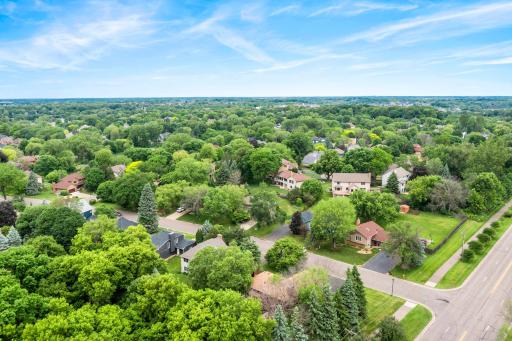 High-altitude neighborhood panoramic view emphasizing wide streets, plentiful green space, and convenient suburban community layout.