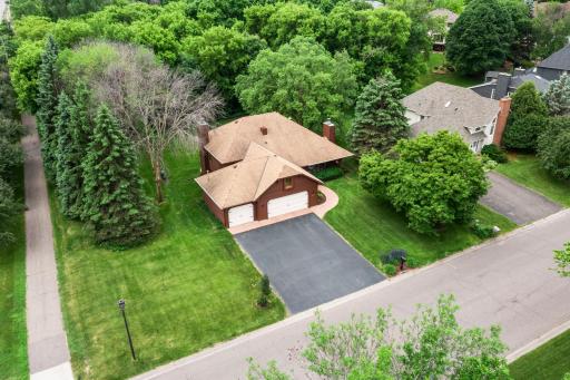 Elevated side view emphasizing the generous lot size and serene, park-like setting.