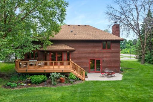 Broad view of the entire rear exterior, showcasing the excellent balance of open lawn and shaded relaxation spaces.