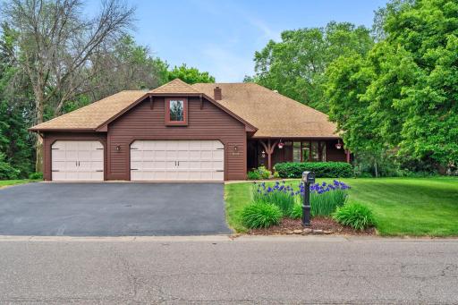 Crisp street-level presentation showing the flawless integration of the home into its lush, green environment.