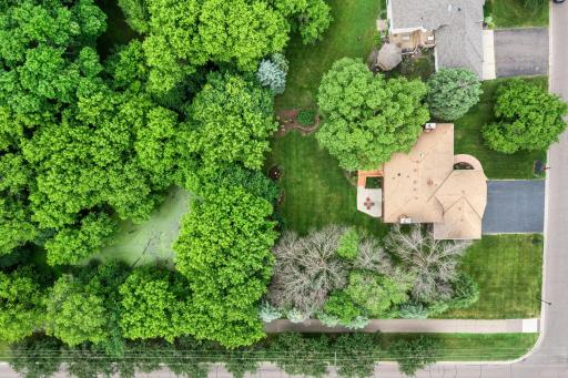 Top-down bird's-eye perspective illustrating the home's impressive lot size, deep driveway, and a private natural pond area right in the backyard.