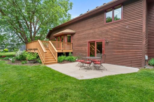 View from the lawn highlighting the lower concrete patio, ideal for a secondary outdoor dining arrangement.