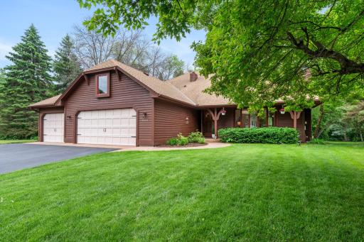 Beautifully framed front elevation highlighting the serene yard, mature canopy, and covered entry walkway.