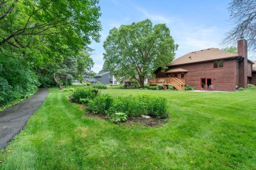 Deep backyard footprint bordered by a paved walking trail across the house and an abundance of mature trees providing a private oasis.