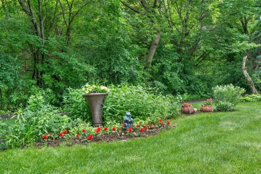 Close-up look at the meticulously maintained perennial landscaping and flower arrangements in the yard.