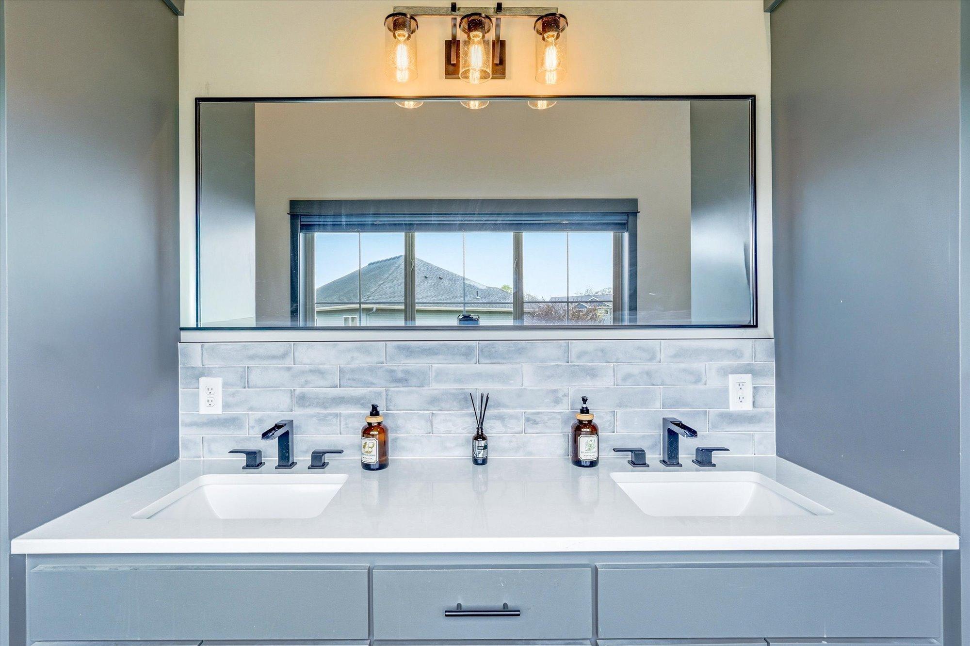 Elegant double-sink vanity with modern fixtures, stylish lighting, and ample storage space for everyday convenience.