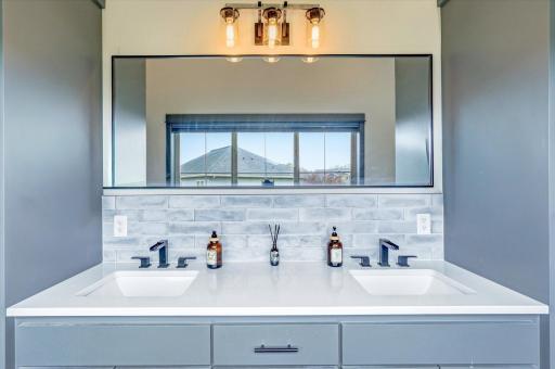 Elegant double-sink vanity with modern fixtures, stylish lighting, and ample storage space for everyday convenience.