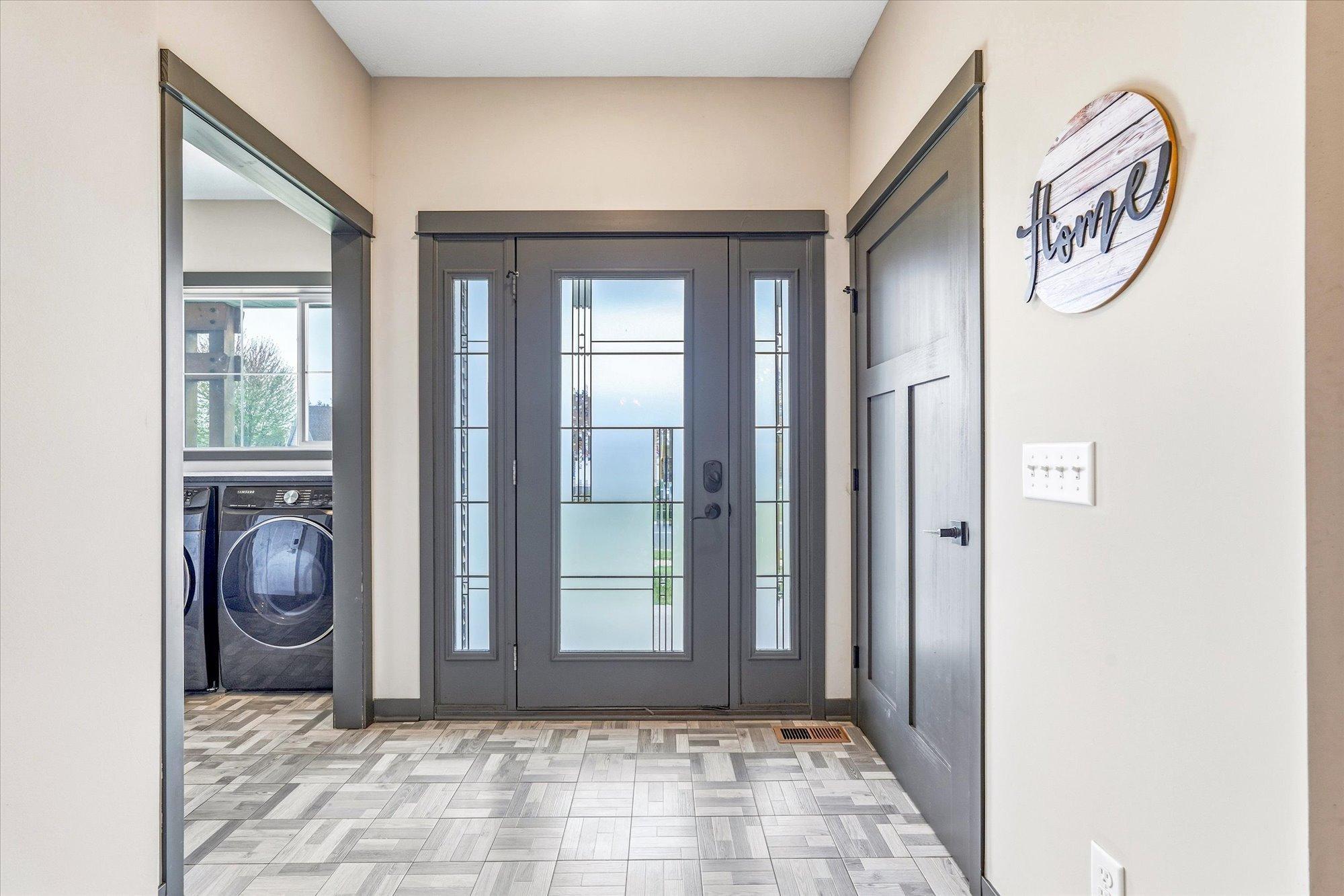 Elegant front entry with decorative glass door, transom-style sidelights, and impressive natural light.