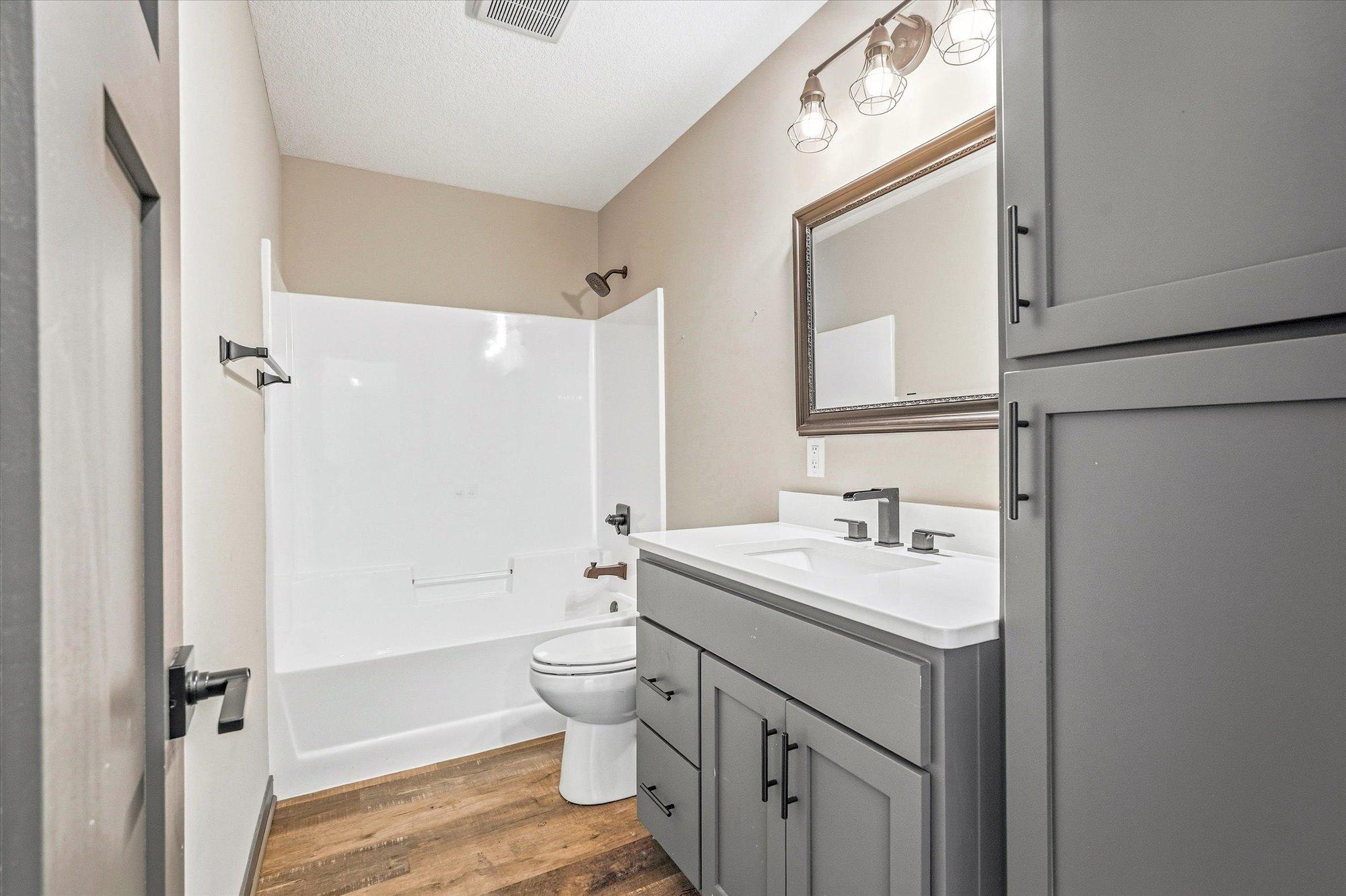 Lower-level full bathroom offers modern finishes, updated fixtures, and additional storage cabinetry.