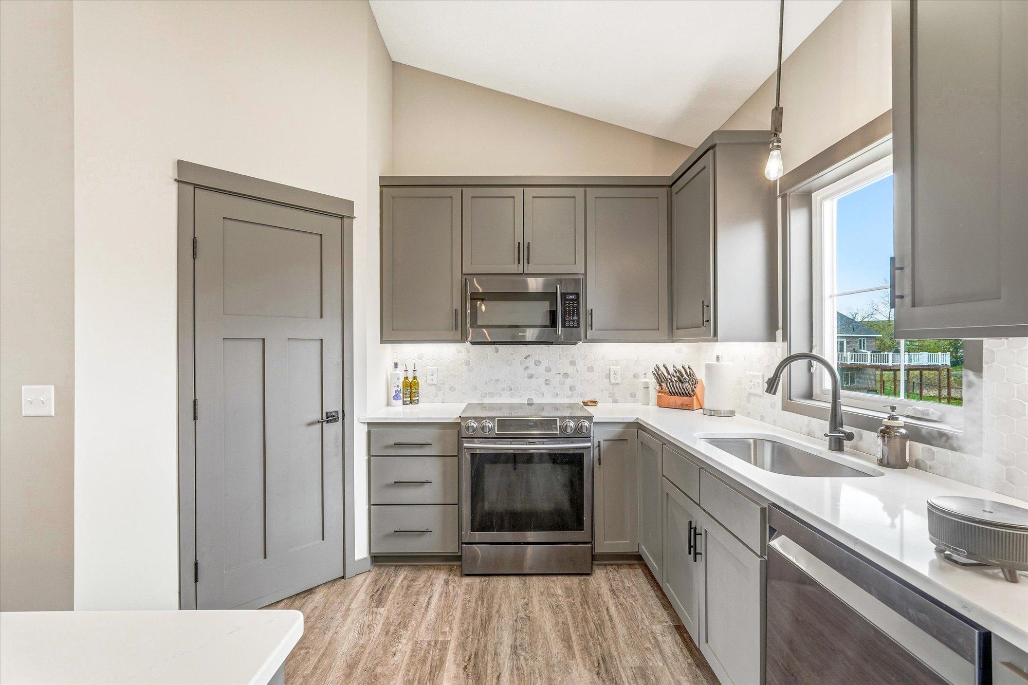 Stunning kitchen with abundant cabinet space, modern lighting, walk-in pantry, and a large center island perfect for gathering.