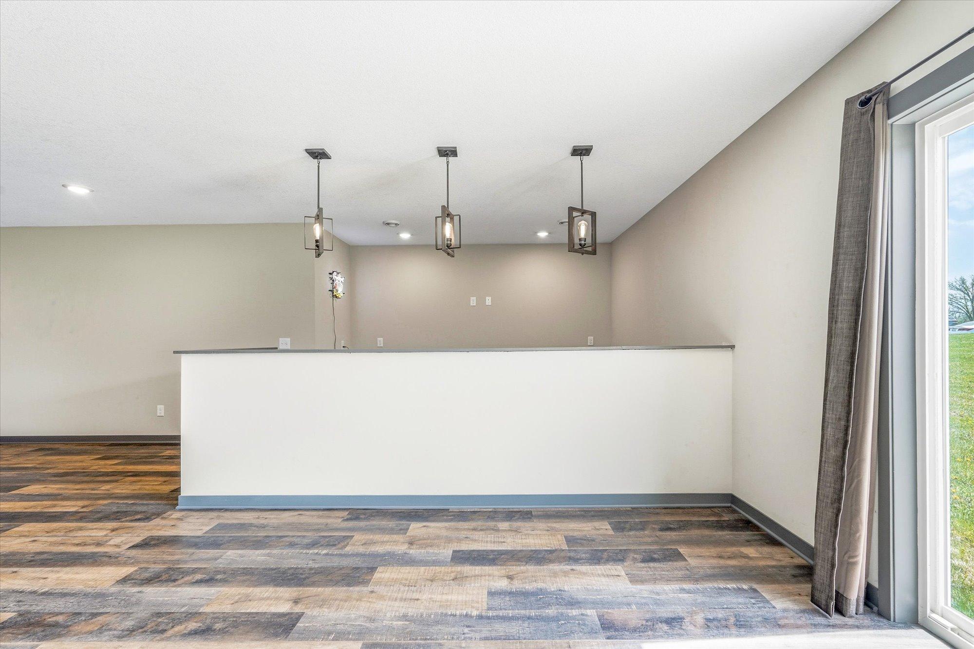 Lower-level bar area with stylish pendant lighting provides the perfect setup for gatherings and game nights.