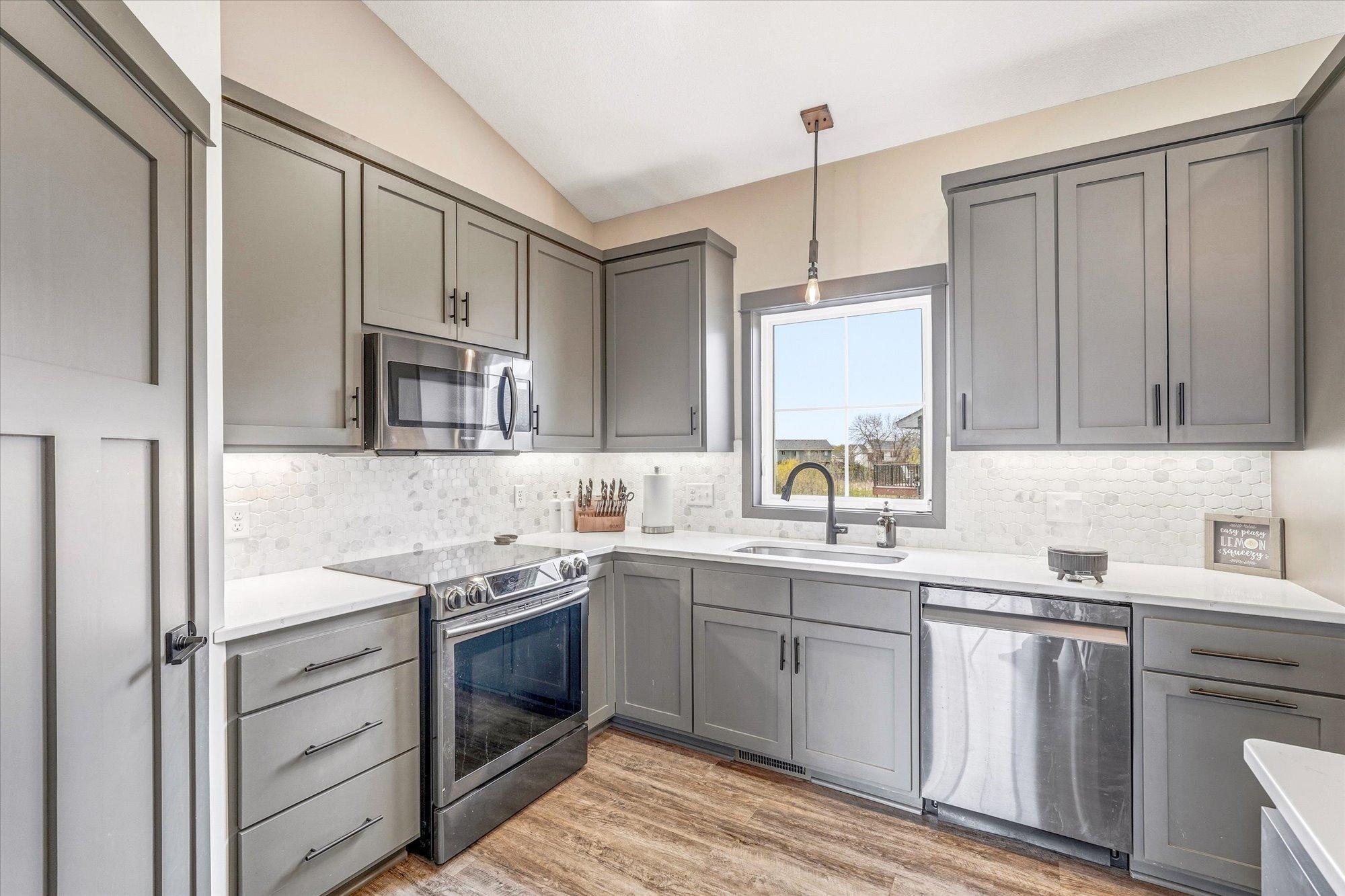 Bright and functional kitchen with abundant workspace, under-cabinet lighting, and a beautiful window above the sink.