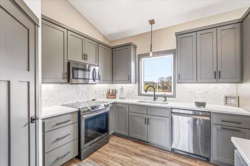 Bright and functional kitchen with abundant workspace, under-cabinet lighting, and a beautiful window above the sink.