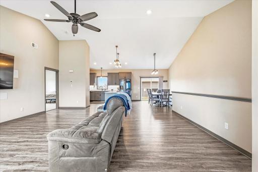 Expansive open-concept main living area with soaring vaulted ceilings, luxury flooring, and abundant natural light throughout.