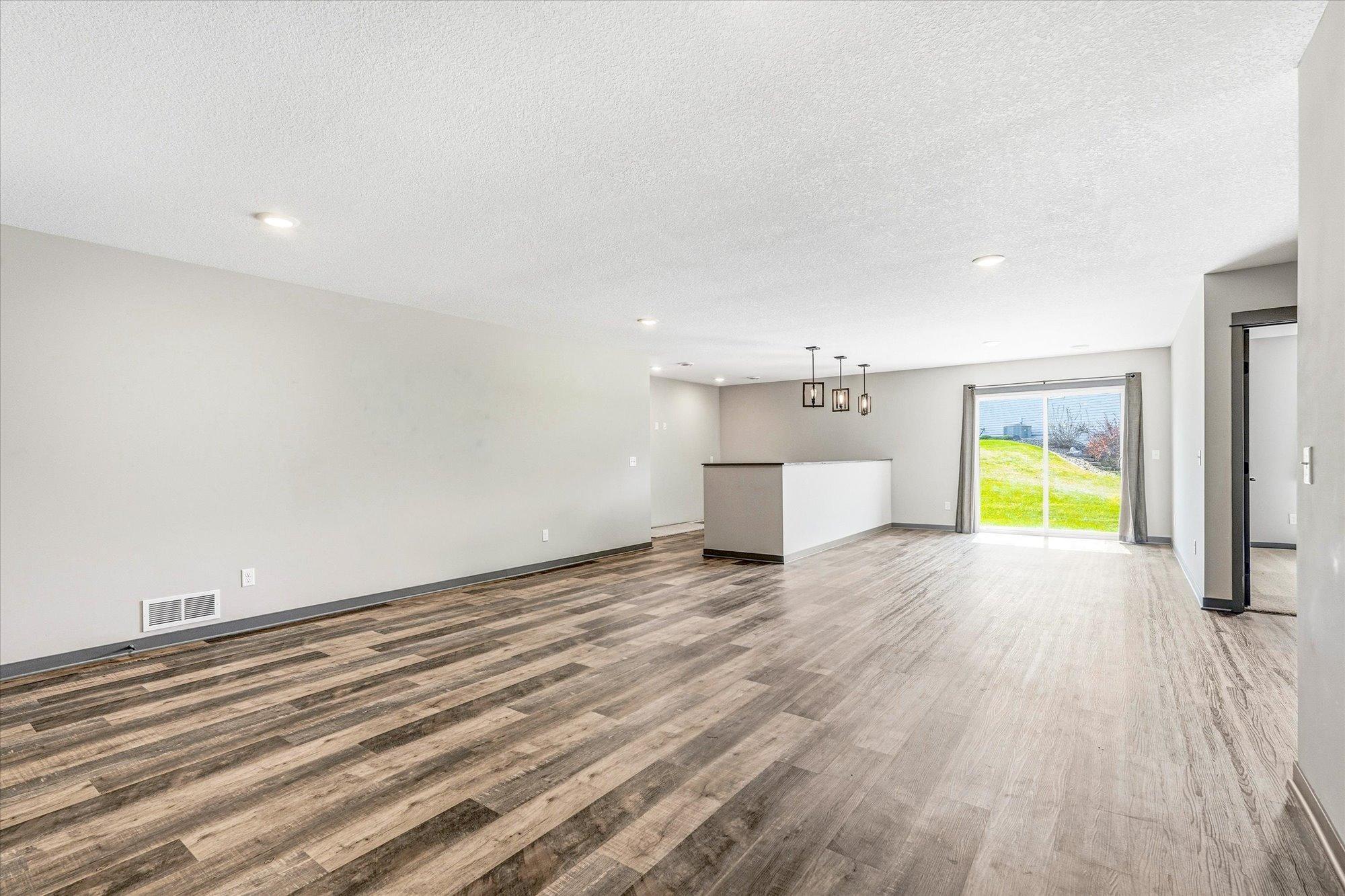 Bright and spacious walkout lower level features durable flooring, recessed lighting, and access to the backyard.