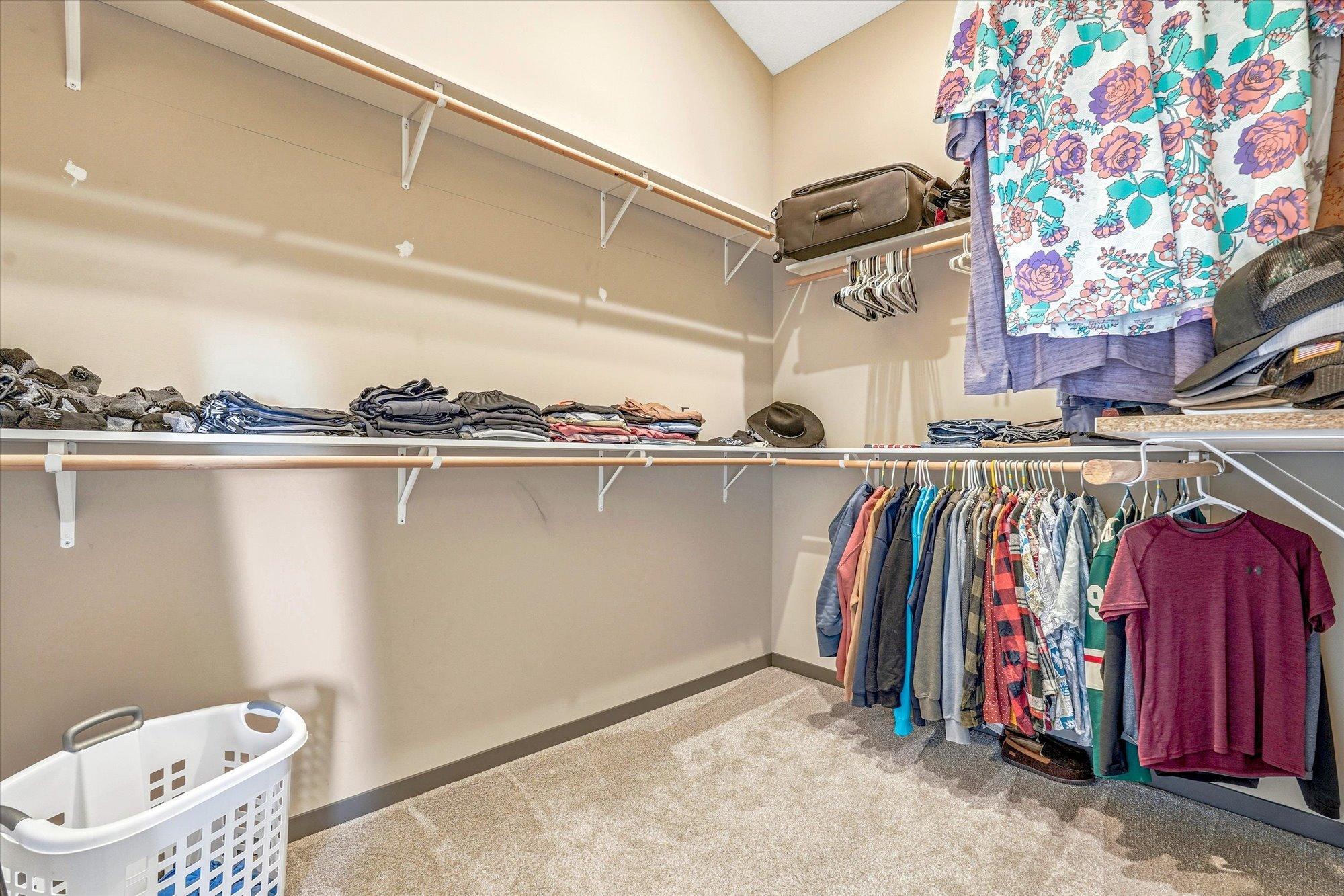 Expansive walk-in closet with built-in shelving and abundant hanging space for organized storage.
