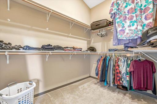 Expansive walk-in closet with built-in shelving and abundant hanging space for organized storage.