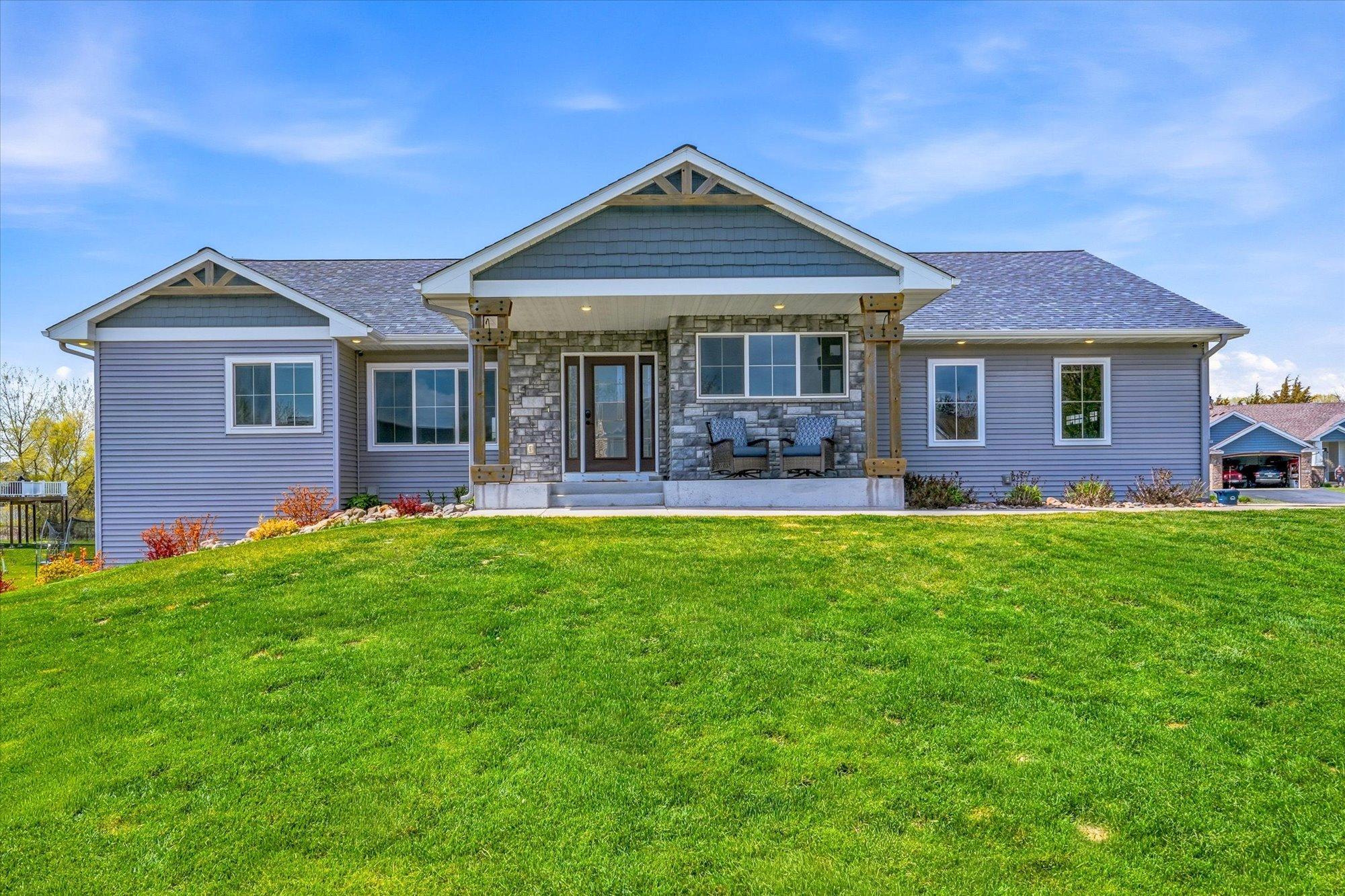 Inviting covered front porch with rustic timber posts creates the perfect space to relax and enjoy peaceful neighborhood views.