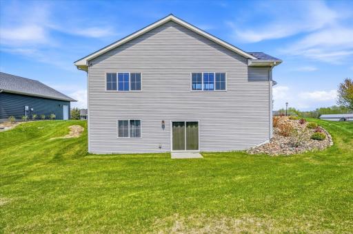 Rear exterior showcases the homeâs spacious footprint, walkout design, and beautifully maintained lot.