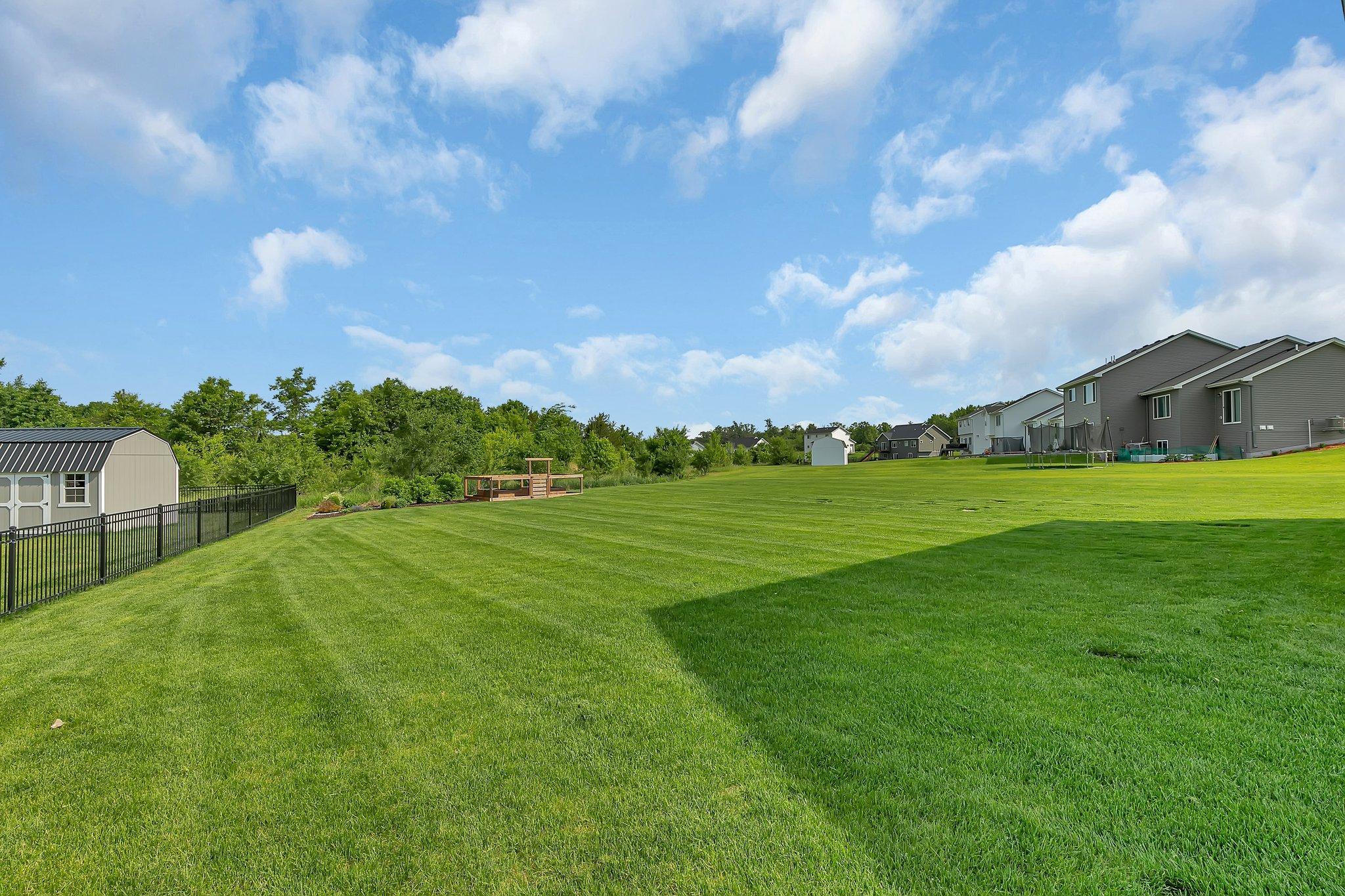 Here is a summer view of the well maintained backyard and full trees. An irrigation system help maintain this beautiful yard, and the water bill is covered in the cost of the monthly association dues.