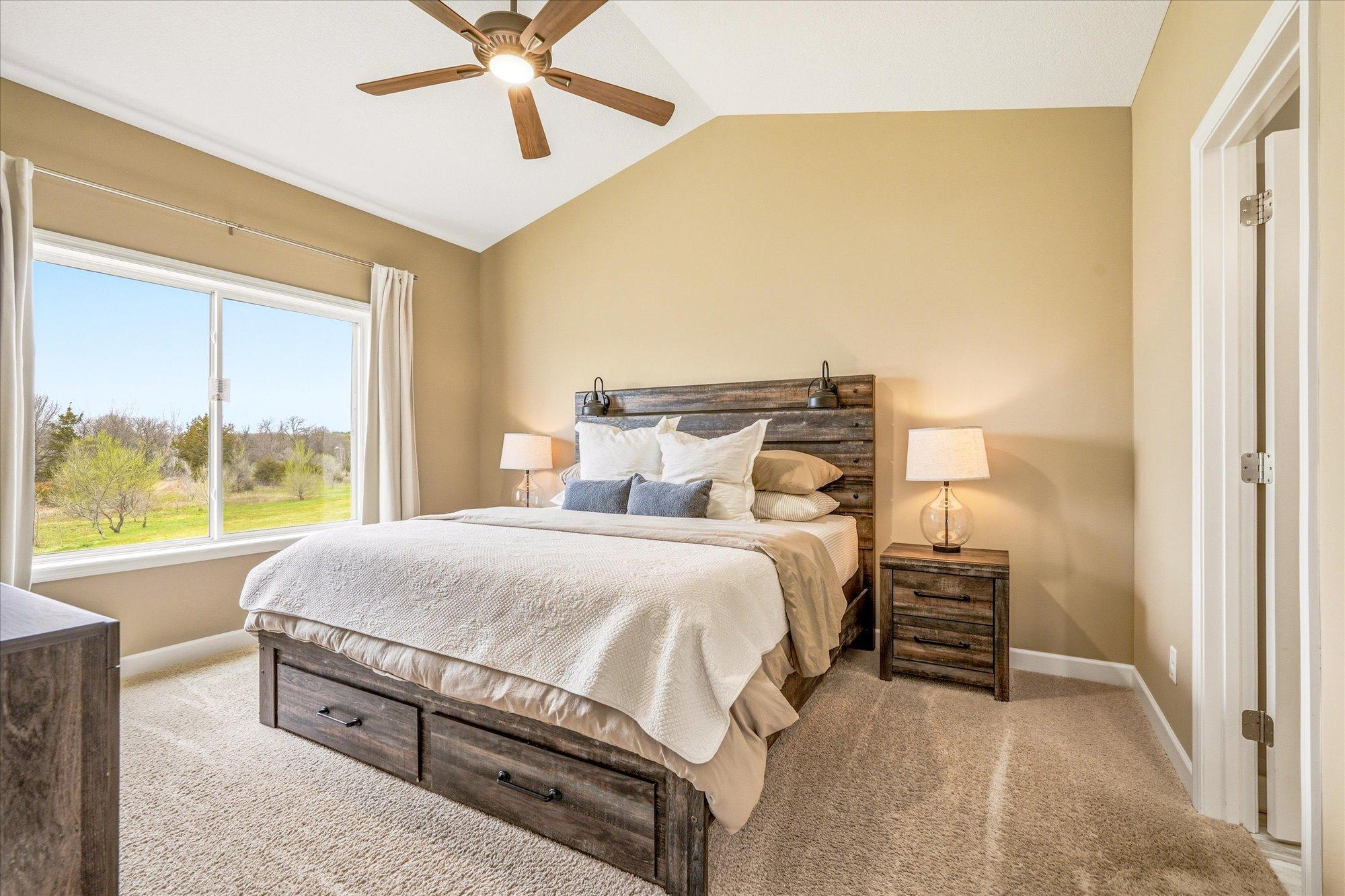 The main level primary bedroom features a vaulted ceiling.