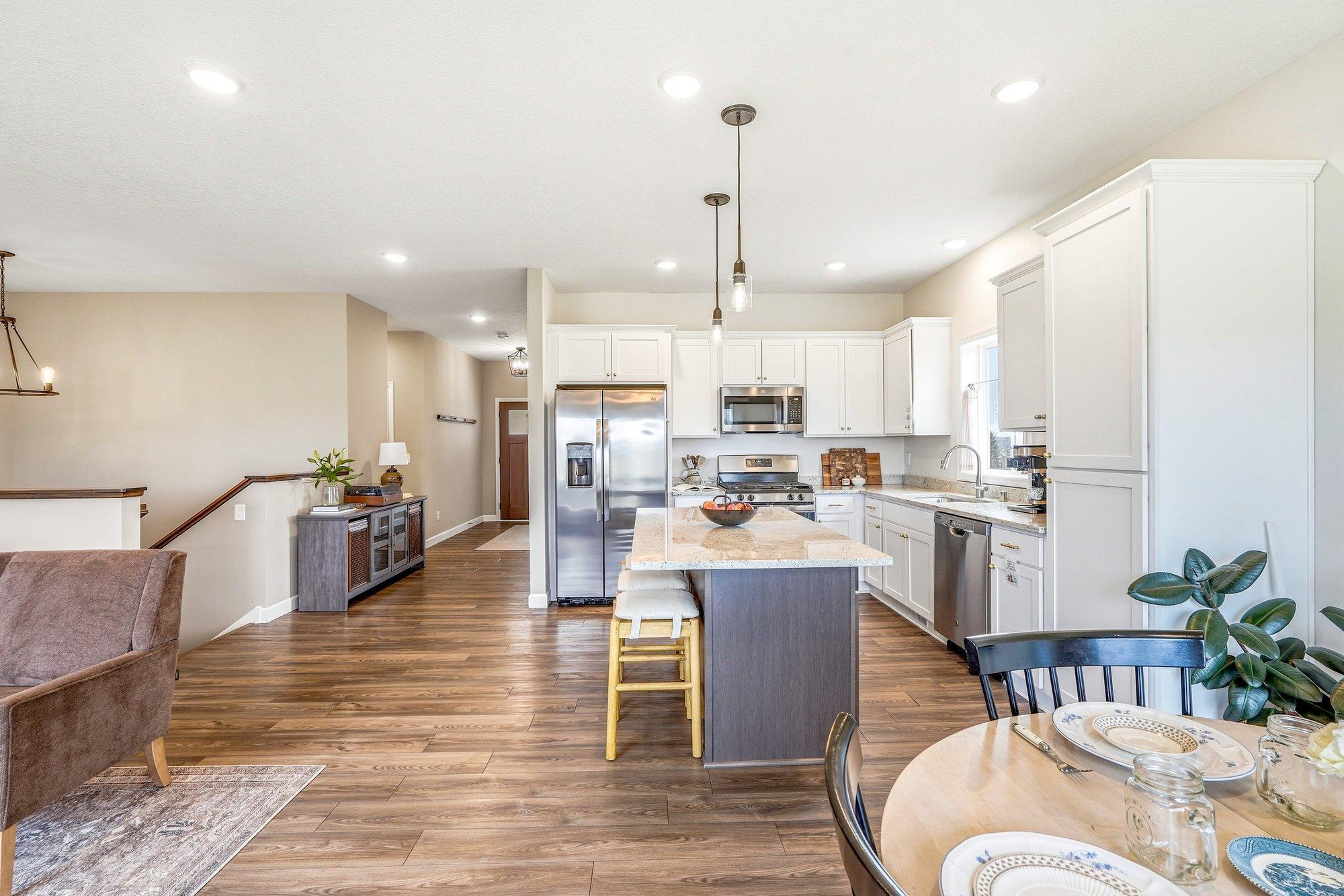 Another view of the main level area showcasing the abundance of natural light and great amount of lighting within the home as well.